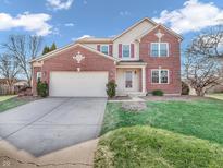 Two-story brick home featuring an attached two car garage, red shutters, and a well-maintained front lawn at 6663 Trailside Dr, Avon, IN 46123