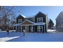 Two-story house with green and tan siding, white trim, and snowy front yard at 847 Udell St, Indianapolis, IN 46208