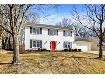 Charming two-story home with a red front door and manicured landscaping at 9275 Eastwind Dr, Indianapolis, IN 46256