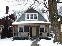 Gray house with wooden porch, steps, and snowy front yard at 1138 W 33Rd St, Indianapolis, IN 46208