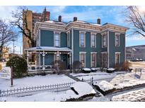 Two-story Victorian home with a wraparound porch and snow-covered lawn at 125 W 11Th St, Anderson, IN 46016