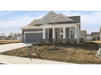 Charming single Gathering home with grey siding, stone accents, a two-car garage, and a neatly landscaped front yard at 14878 Desert Orchid Dr, Westfield, IN 46074