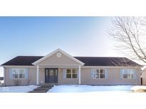 Tan one-story house with gray door, snow-covered lawn, and leafless tree at 1685 Juniper Dr, Columbus, IN 47201