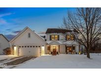 Two-story white brick home with a covered porch and attached two-car garage. Snow covered lawn at 17895 Hollow Brook Ct, Noblesville, IN 46062