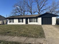 Ranch style home with white brick exterior, black accents, and a grassy lawn at 2450 Morning Star Dr, Indianapolis, IN 46229