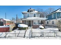 Two-story house with brick front and covered porch, snow-covered yard at 2957 Winthrop Ave, Indianapolis, IN 46205