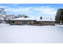 Ranch home exterior, snow covered yard, wood deck at 457 S High School Rd, Indianapolis, IN 46241