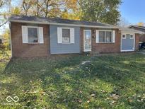 Brick ranch house with gray siding, white shutters, and a well-maintained lawn at 709 Andrea Dr, Beech Grove, IN 46107