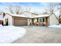 Updated ranch home with rocking chairs on the porch, new garage door and landscaping at 8325 Anemone Ln, Indianapolis, IN 46219