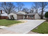 Charming home featuring a well-manicured lawn and a concrete driveway leading up to a two-car garage at 8325 Anemone Ln, Indianapolis, IN 46219