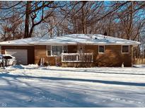 Brick ranch home with attached garage, snowy front yard, and a partially visible deck at 837 S Brentwood Ave, Indianapolis, IN 46239