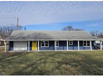 Newly renovated Ranch home featuring a blue exterior, white trim, and a bright yellow front door at 1736 E Gimber St, Indianapolis, IN 46203