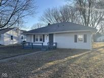 Charming single-story home featuring a blue-painted porch, neutral siding and a well-maintained front yard at 2116 N Rosewood Ave, Muncie, IN 47304