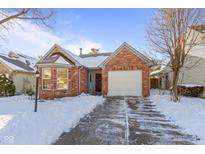 Brick ranch home with attached garage, snowy driveway, and landscaping at 4943 Peony Pl, Indianapolis, IN 46254