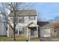 Brick and vinyl-sided two-story house with attached garage and landscaping at 504 Grand Woods Dr, Indianapolis, IN 46224