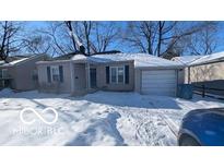 Cute ranch home with attached garage, snow-covered yard at 5708 N Keystone Ave, Indianapolis, IN 46220