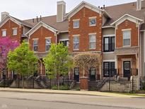 Charming brick townhomes with well-manicured landscaping and wrought iron fences along the sidewalk at 6595 Reserve Dr, Indianapolis, IN 46220