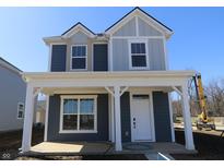Charming two-story home with a covered front porch and a combination of blue and gray siding at 1705 Real St, Indianapolis, IN 46240