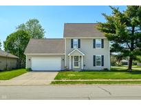 Charming two-story home with attached two car garage, a well-maintained lawn and colorful flowerbeds at 2062 Sumpter Trl, Columbus, IN 47203