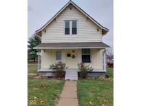A charming yellow house with a front porch and yard at 325 S Market St, Thorntown, IN 46071