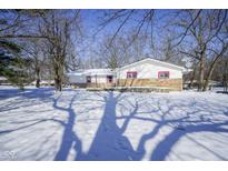 White house with stone accents, snow-covered yard, and tree shadows at 4201 Westbourne Dr, Indianapolis, IN 46205