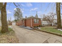 Brick ranch home with driveway, landscaping, and detached garage at 5861 Hillside Ave, Indianapolis, IN 46220