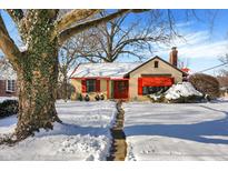 Snow-covered charming house with red awnings and stone pathway at 6072 Meridian St W Dr, Indianapolis, IN 46208