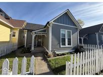 Charming gray home with a white picket fence and well-maintained front yard landscaping at 630 E Mccarty St, Indianapolis, IN 46203