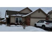 Tan house with a brown roof, brick accents, and a two-car garage; snow on the ground at 1294 Lexington Trl, Greenfield, IN 46140