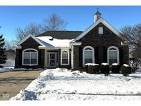 Brick ranch home with snow-covered landscaping and a welcoming front entrance at 12998 Brookhaven Dr, Fishers, IN 46037