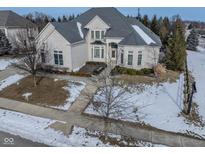 Two-story house with gray roof and white brick exterior, nestled on a tree-lined street at 14516 Copper Ridge Dr, Fishers, IN 46040