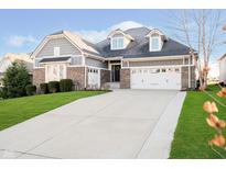 Charming home featuring a brick and siding facade, complemented by a well-manicured lawn and a three-car garage at 16348 La Paloma Ct, Noblesville, IN 46060