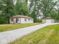 Cute ranch home with a gravel driveway and detached garage at 305 Patterson Rd, Columbus, IN 47203
