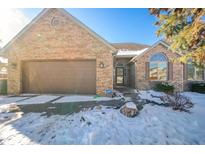 Brick house with brown garage door, snow-covered yard, and landscaping at 5105 S Montego Way, Muncie, IN 47302