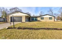 Ranch home with attached garage and landscaped lawn at 6036 Manning Rd, Indianapolis, IN 46228