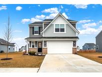 Two-story house with gray siding, white garage door, and landscaping at 6869 Orchard Run Cir, Whitestown, IN 46075