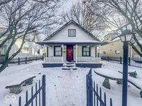 Charming house with a red door and snow covered yard at 709 W 32Nd St, Indianapolis, IN 46208