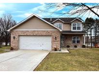 Charming two-story home with brick accents, attached two-car garage, and cozy front yard at 10565 Camille Ct, Indianapolis, IN 46236
