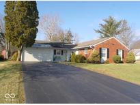 Brick ranch house with attached garage and landscaped lawn at 1256 N Eaton Ave, Indianapolis, IN 46219