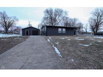 Newly renovated home with dark siding, detached garage, and a paved driveway at 1384 Cross St, Martinsville, IN 46151