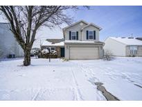 Charming two-story home featuring a two-car garage and inviting curb appeal, all dusted with winter snow at 3246 Tupelo Dr, Indianapolis, IN 46239