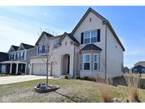 Charming two-story home with a three car garage, brick facade and manicured lawn at 4061 Omaha Dr, Bargersville, IN 46106