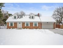 Brick ranch home with attached garage, freshly landscaped yard, and snow-covered lawn at 4725 S Rural St, Indianapolis, IN 46227