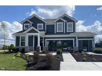 Two-story home with gray siding, stone accents, and landscaped yard at 5529 Noble Crossing W Pkwy, Noblesville, IN 46062