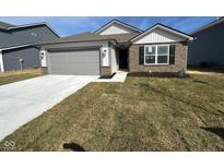 Charming single-story home featuring stone accents, a gray garage door, and freshly laid sod in the front yard at 6618 Sulgrove Pl, Indianapolis, IN 46221
