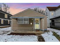 Charming bungalow with covered porch and snow-covered yard at 837 Birch Ave, Indianapolis, IN 46221