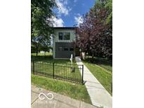 Modern two-story home with a well-manicured lawn and a charming black fence at 1656 Roosevelt Ave, Indianapolis, IN 46218