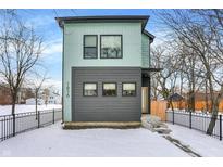 Two-story modern home with gray and teal exterior, snow-covered yard, and black fence at 1656 Roosevelt Ave, Indianapolis, IN 46218