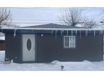 Dark brown studio with white door, snow on roof and ground at 1918 Elm St, Columbus, IN 47201