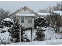 Cozy ranch home with snow-covered yard and chain link fence at 3222 W Minnesota St, Indianapolis, IN 46241